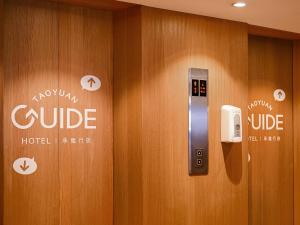 a wooden door with a phone on the wall at Guide Hotel Taoyuan Fuxing in Taoyuan