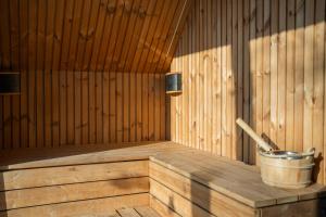 a wooden tub in a sauna with a bucket at Moonloungeresort in Kalviai