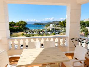a balcony with a table and chairs and a view of the water at Villa Lions in Ksamil