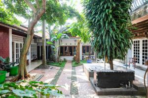 a courtyard of a house with trees and plants at Hotel Srikandi Semarang RedPartner in Candi