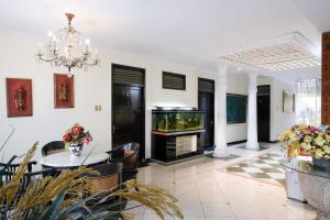 a living room with a dining table and a fish tank at Hotel Srikandi Semarang RedPartner in Candi