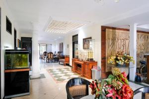 a living room with a table with flowers on it at Hotel Srikandi Semarang RedPartner in Candi
