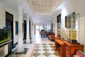 a hallway with columns and a room with a fish tank at Hotel Srikandi Semarang RedPartner in Candi