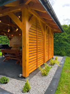 a wooden gazebo with a picnic table in a garden at Noclegi u Eweliny in Zator