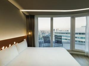 a bedroom with a large bed and a large window at Ibis Styles Lisboa Centro Marquês de Pombal in Lisbon