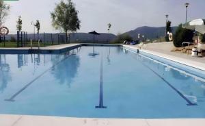 ein großes Schwimmbecken mit blauem Wasser in der Unterkunft Aneto Dúplex en Badaguas in Badaguás