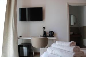 a room with a desk and a pile of towels at Dimora Letizia, Apulian Rooms in Sammichele di Bari +8 photos
