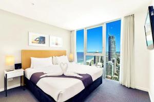a bedroom with a large bed and a large window at Luxurious 2 Bedroom Apartment - Ocean View in Gold Coast