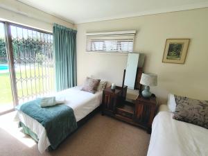 a bedroom with two beds and a window at Francolin's Rest Guest Suite in Sweet Valley