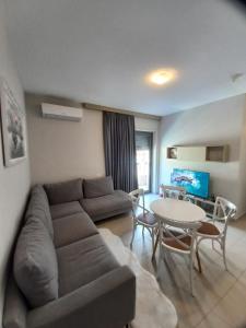a living room with a couch and a table at Pool View Private Apartment in Vlorë