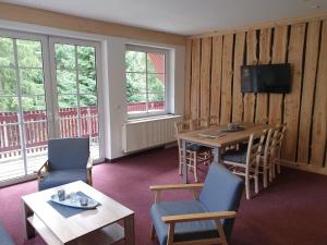 a hotel room with a table and chairs and windows at Sauberghaus Wohnung 2 in Breitenbrunn
