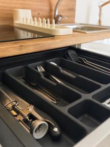 a black sink with utensils in a drawer at Aparthotel Fuenlabrada Central in Fuenlabrada