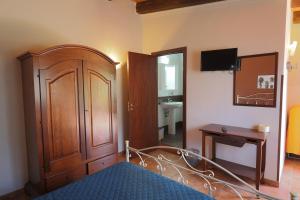 a bedroom with a bed and a wooden cabinet at Cavagrande Guest House in Avola
