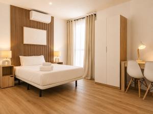 a bedroom with a bed and a table and chairs at Aparthotel Fuenlabrada Central in Fuenlabrada