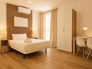 a bedroom with a bed and a table and a desk at Aparthotel Fuenlabrada Central in Fuenlabrada +5 photos