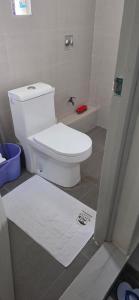a bathroom with a toilet and a white rug at Wattle Residence Ngong in Ngong