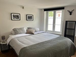 a bedroom with a large white bed with a window at Week end à Spa in Spa