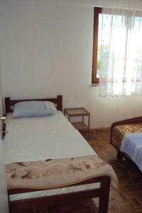 a bedroom with a large bed and a window at Apartments Marko in Vrsi