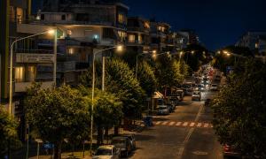 a city street at night with cars parked at Διαμέρισμα 4 dimos in Alexandroupoli