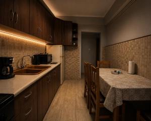 a kitchen with a sink and a table with chairs at Διαμέρισμα 4 dimos in Alexandroupoli