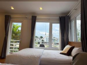 a bedroom with a bed and a large window at Cherry Luxury Hotel in Da Lat