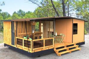 a tiny house with a deck and a table at Camping du Lac de Cazaux in La Teste-de-Buch