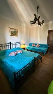 a bedroom with two beds and a chandelier at Piano Piano Affittacamere in Andagna