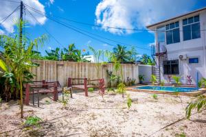 a backyard with a fence and a house at Marumbi Beach House in Marumbi