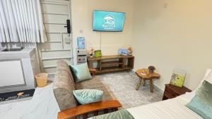a living room with a couch and a tv on the wall at Wattle Residence Ngong in Ngong