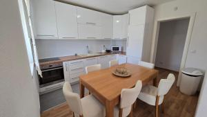 a kitchen with a wooden table and white cabinets at منتجع سراييفو - Sarajevo Resort in Sarajevo +15 photos