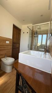 a bathroom with a large white tub and a toilet at Piano Piano Affittacamere in Andagna