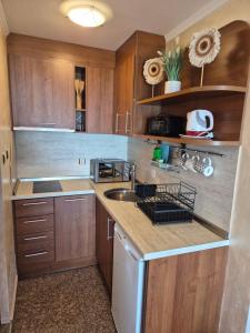 a kitchen with wooden cabinets and a stainless steel sink at Guest Rooms Skalite in Sozopol