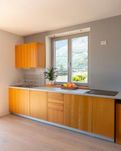 a kitchen with wooden cabinets and a window at View & Chill Apartment in Riva del Garda +13 photos