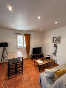 a living room with a couch and a table at Studio au Pied de la ste Victoire in Puyloubier