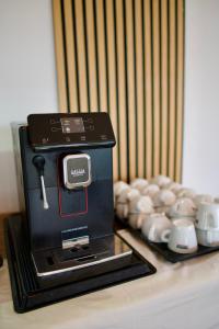 a coffee maker sitting next to a pile of cups at SANIMAR By Mono Alex in Kassandra