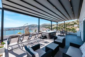 a balcony with chairs and a view of the water at Eleni Guest House in Sarandë