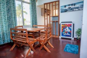 a dining room with a wooden table and a bench at Marumbi Beach House in Marumbi