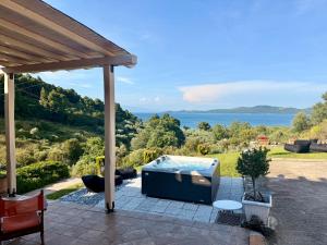 a hot tub on a patio with a view of the water at STONEHOUSE & CASA AL SOLE e AL MARE in Nea Roda