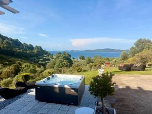 a hot tub on a patio with a view of the water at STONEHOUSE & CASA AL SOLE e AL MARE in Nea Roda