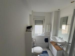 a white bathroom with a toilet and a sink at Zentral in Siegen