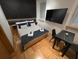 a bedroom with a bed and a desk and a television at Apartmaji Sonce in Piran