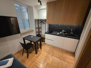 a small kitchen with a sink and a table at Apartmaji Sonce in Piran