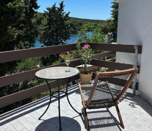 a table and chair on a balcony with a view at Molat Bay View in Molat
