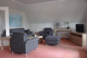 a living room with two chairs and a tv at Hotel Stadt Lübeck in Timmendorfer Strand