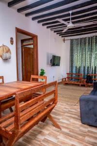 a dining room with a wooden table and a ceiling fan at Marumbi Beach House in Marumbi