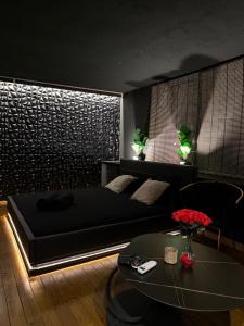 a bedroom with a black bed and a table at MIRAGE47SPA - Private Spa Suite with Jacuzzi & Sauna in Marbella in Marbella +12 photos