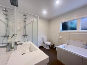 a bathroom with a sink and a tub and a toilet at Campvan Stay in Auckland
