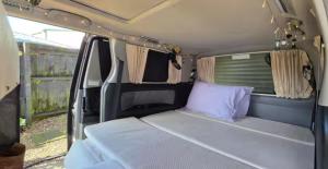 a small bed in the back of a van at Campvan Stay in Auckland