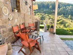 a patio with chairs and a table on a stone building at STONEHOUSE & CASA AL SOLE e AL MARE in Nea Roda +38 photos