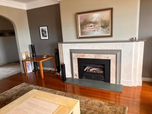 a living room with a fireplace and a table at Darling Point with Harbour Views in Sydney